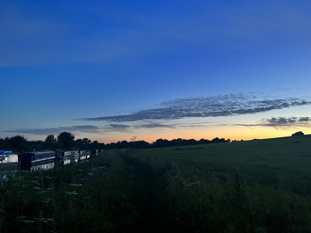 Image shows the Kennet and Avon Canal with Canal Boats at Sunset 